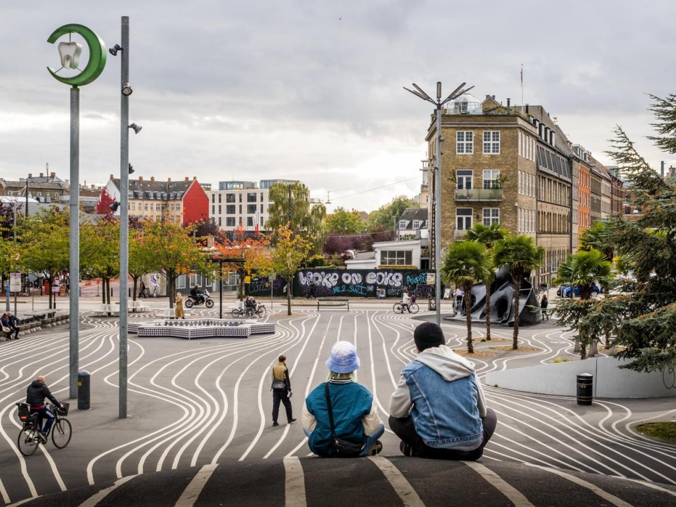 Two people sitting in the area called Superkilen on Nørrebro